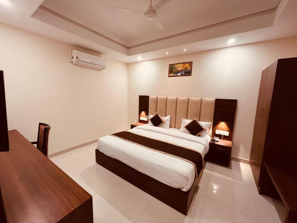 um quarto com uma cama grande num quarto em Gamla INN, Munnar em Munnar