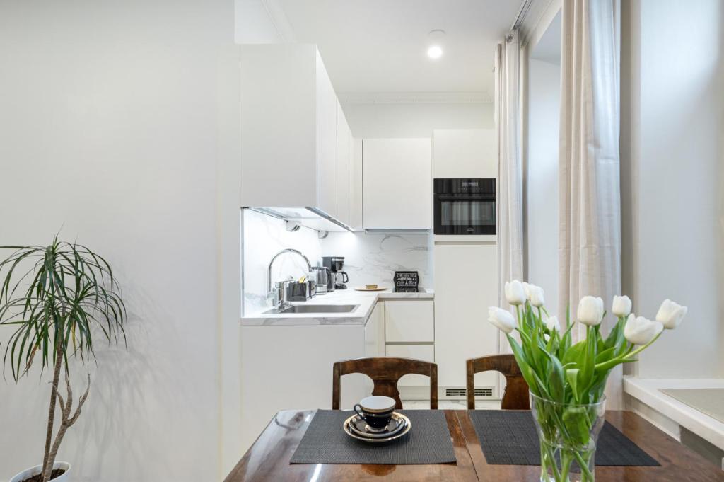 a kitchen and dining room with a table and chairs at Cosy, brand new apartment in best area in Helsinki