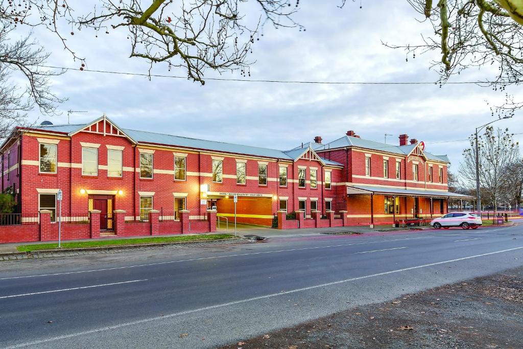 un edificio de ladrillo rojo con un coche aparcado delante de él en Lake Inn - Ballarat, en Ballarat