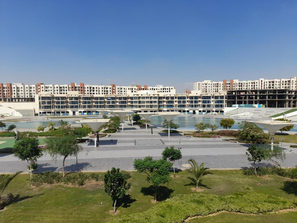 an apartment complex with a courtyard with trees and buildings at نيوم اكتوبر in 6th Of October