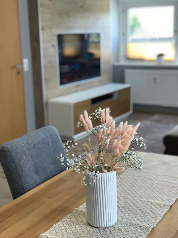 a vase with flowers on a table in a living room at fewo-friends in Reinfeld