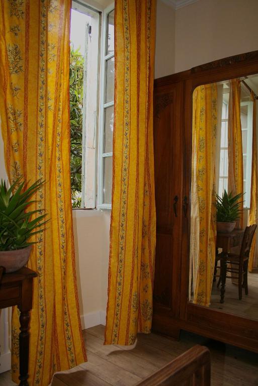 a room with yellow curtains and a window at Le Clos des Laurons in Nyons