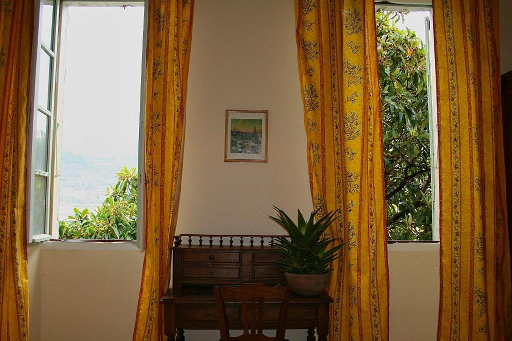 a room with two windows and a table with a plant at Le Clos des Laurons in Nyons