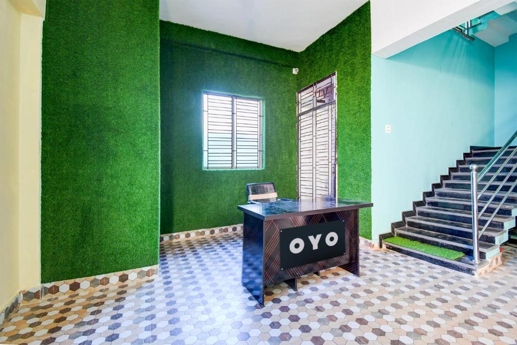 an office with a desk and a green wall at OYO ALYSAN STAY in Bhubaneshwar