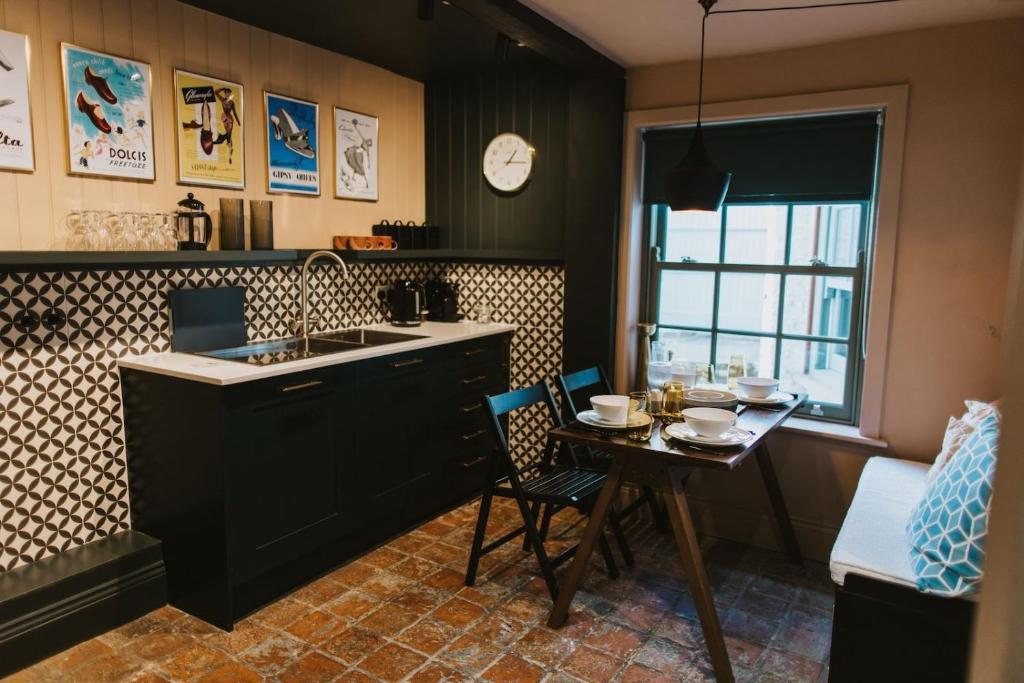 a kitchen with a sink and a table with chairs at Cobblers Cottage Brigg in Brigg