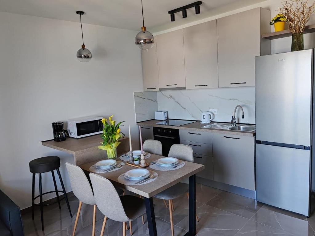 uma cozinha com uma mesa de madeira e electrodomésticos brancos em Sunny Apartment em Kali