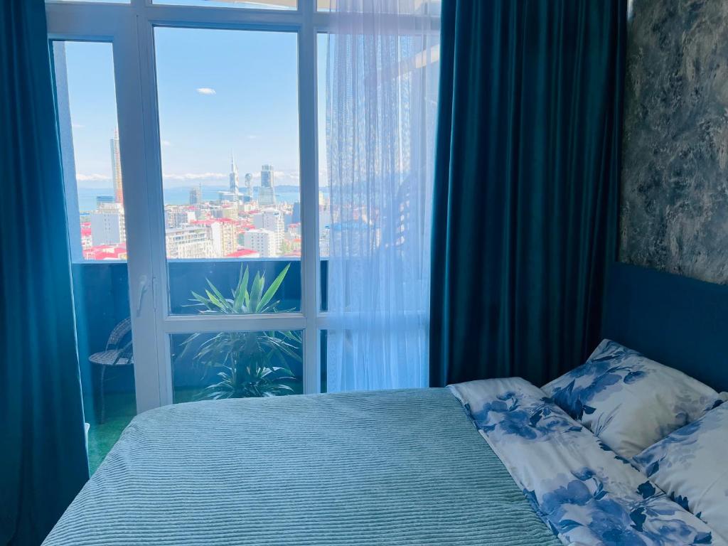 una camera con un letto e una grande finestra di Panorama a Batumi