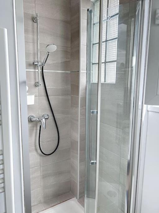 a shower with a glass door in a bathroom at Le Raphaëlle - Compiègne centre in Compiègne