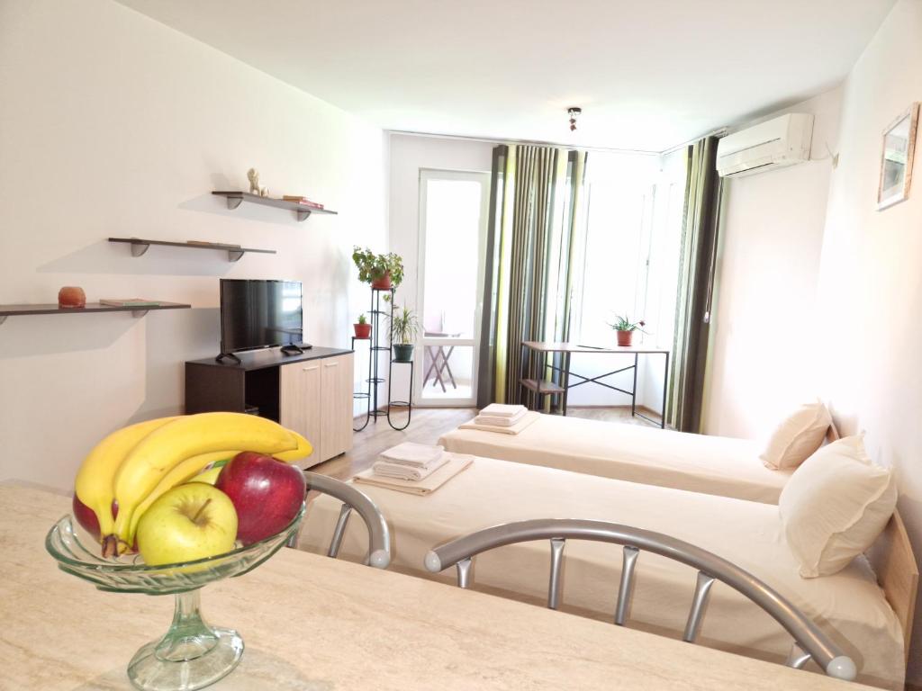 een kamer met 2 bedden en een fruitschaal op een tafel bij Дом Крумови in Boergas