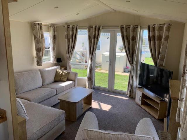 a living room with a couch and a tv at Newbeach Holiday Park - Greenfields in Dymchurch