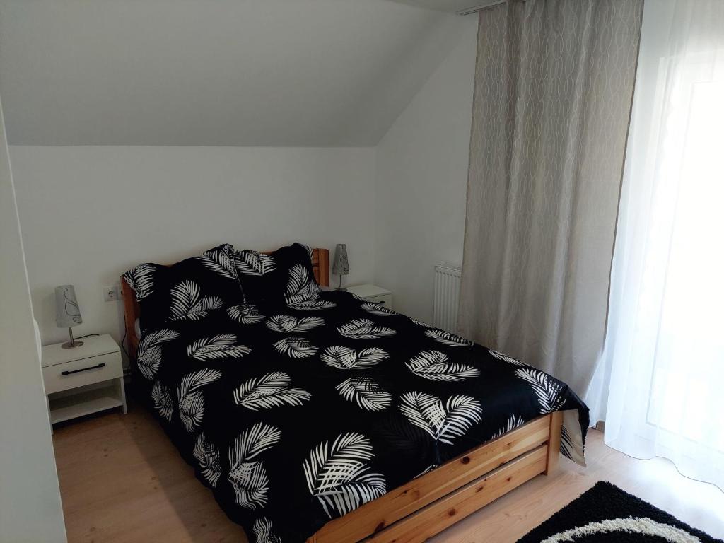 een slaapkamer met een bed met een zwart-wit dekbed bij Casa Mario 2 in Oradea