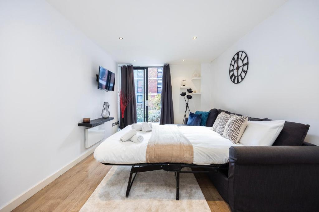 a bedroom with a bed and a couch at Modern 1 BR Apartment Near Shoreditch - 10 Min Walk in London