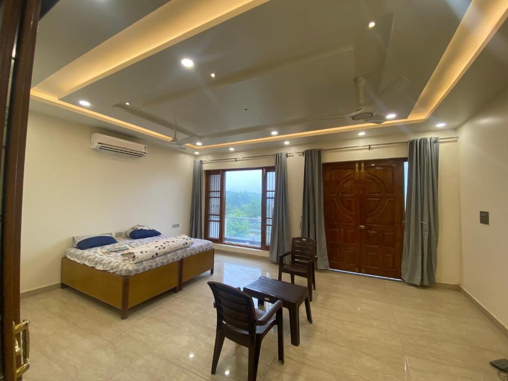 - une chambre avec un lit, une table et des chaises dans l'établissement Paradise rooms, à Lucknow