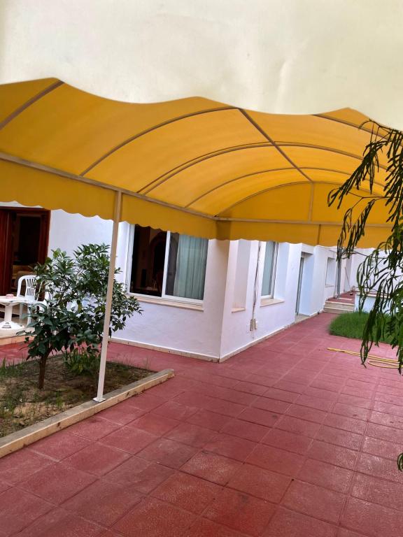 a large yellow umbrella on a patio at Villa richement meublée au cité Ennacer 98€/j in Ariana