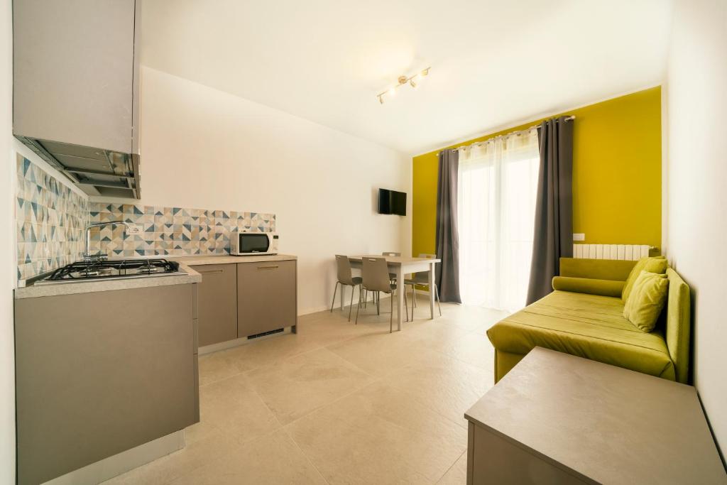 eine Küche und ein Wohnzimmer mit einem Sofa in der Unterkunft Hotel Residence La Rotonda in Tignale