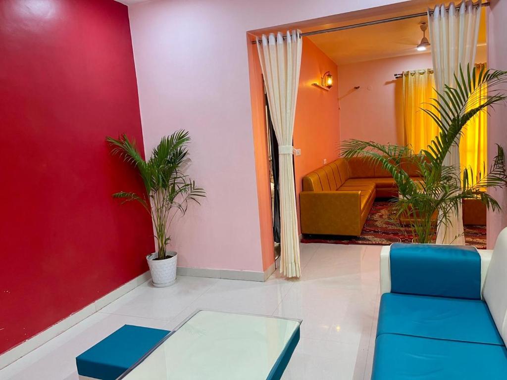 Royal Rajvilas Heights في أودايبور: غرفة معيشة مع أريكة وجدار احمر