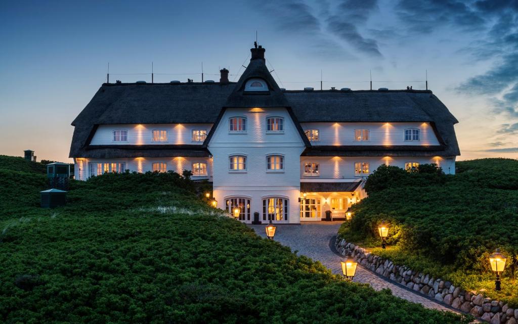 a large white house on a hill with lights at Söl'ring Hof in Rantum