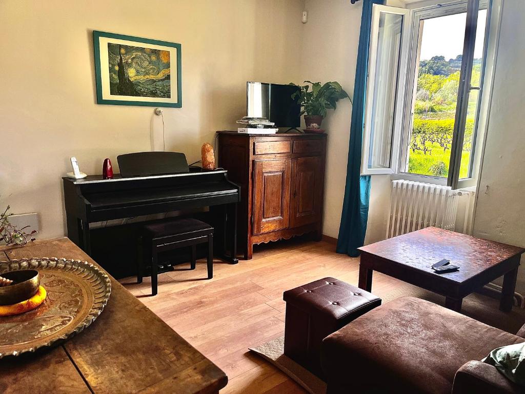 sala de estar con piano y sofá en Le Clos des Laurons, en Nyons