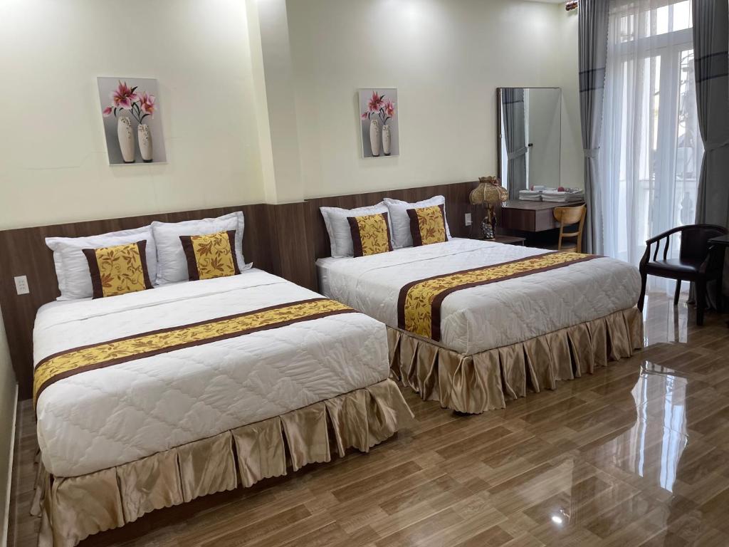 2 camas en una habitación de hotel con en Hoàng đế en Ấp Châu Thới