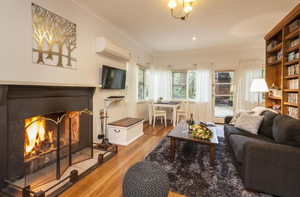 a living room with a couch and a fireplace at Cottage in the Forest in Olinda