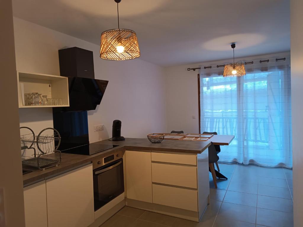 a kitchen with a counter and a table in a room at Appartement au coeur de la station in Les Déserts