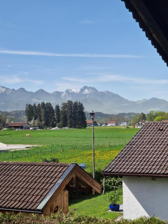 una vista de una granja con montañas en el fondo en Chalet Chiemgau 90 qm 3 Zimmer Balkon en Übersee