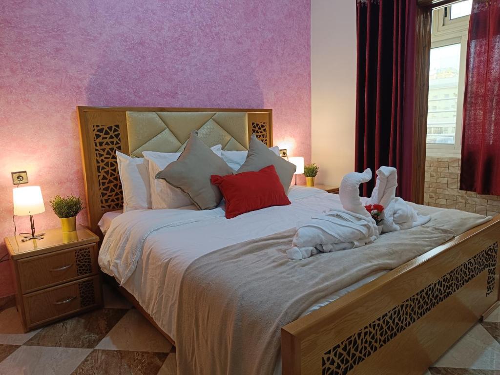- une chambre dotée d'un grand lit avec deux animaux rembourrés dans l'établissement Aljazeera apartment, à Tanger