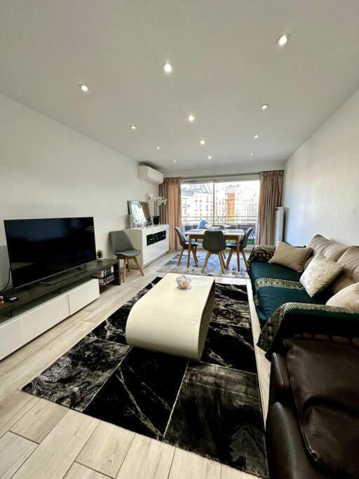 un salon avec un canapé et une télévision dans l'établissement Spacieux et Élégant Appartement - Boulogne - Paris, à Boulogne-Billancourt