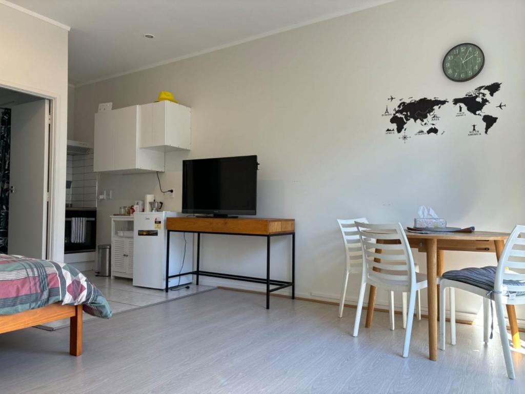 una camera con cucina e tavolo con televisore di epsom tidy white house ad Auckland