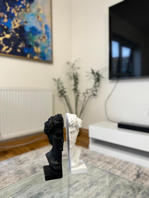 a statue sitting on a glass table in a living room at Luxury Lakeview Apartment in Dartford