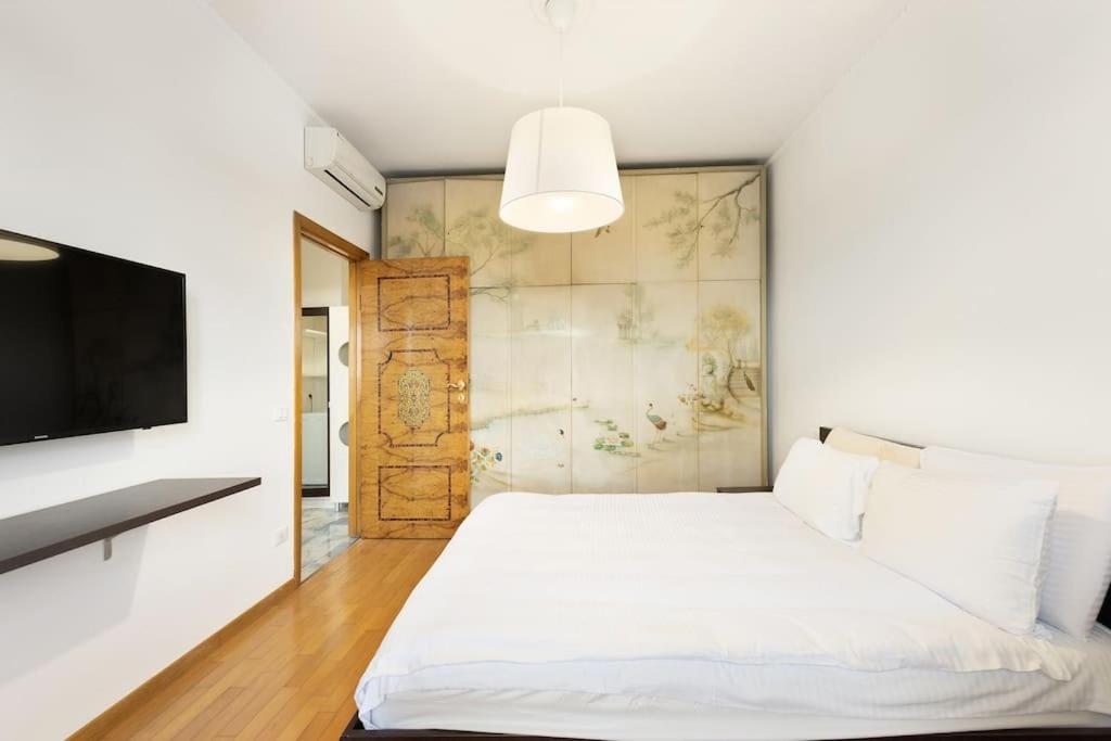 a bedroom with a white bed and a tv at Allianz House - Panoramic San Siro cozy house in Milan