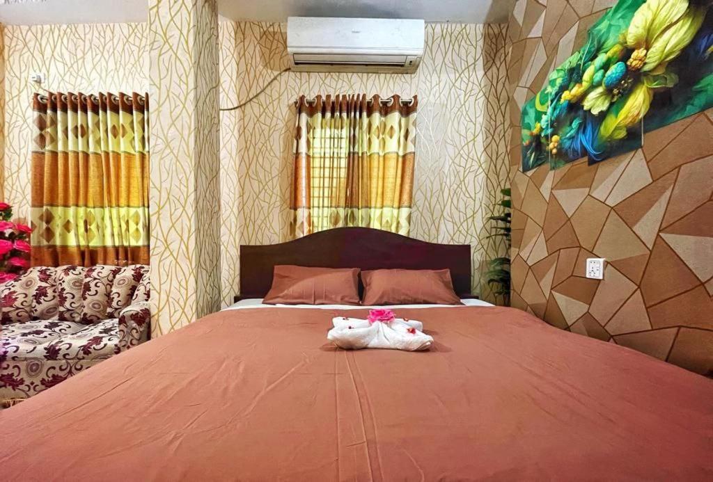 a bedroom with a bed with a stuffed animal on it at Hotel Shogondha Residential, in Dhaka