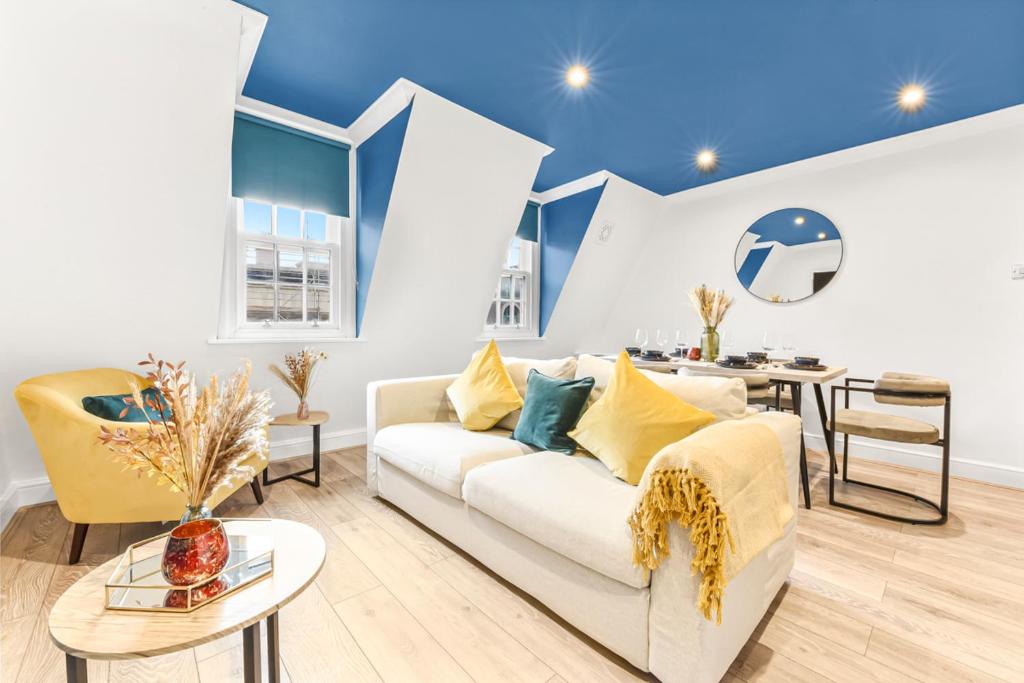 ein Wohnzimmer mit einem weißen Sofa und einem Tisch in der Unterkunft Cosy 2 bed flat near London Eye in London