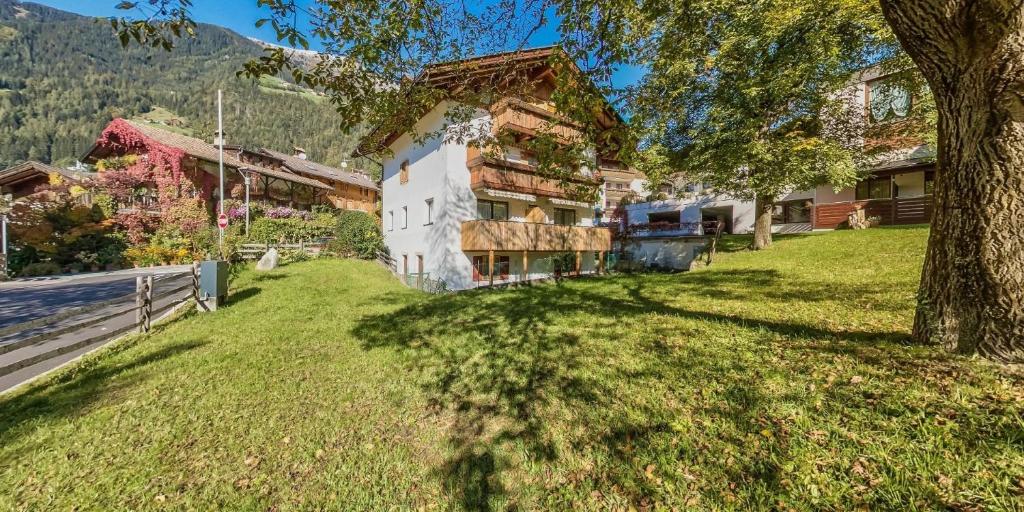 ein Haus auf einem Hügel mit einem Baum im Vordergrund in der Unterkunft Ferienwohnung für 4 Personen ca 35 m in Sankt Leonhard in Passeier, Südtirol Ortler Skiarena in St. Leonhard in Passeier