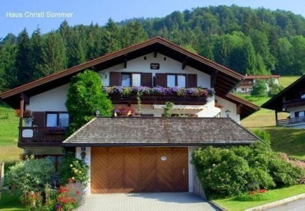 une maison avec un garage et un balcon dans l'établissement Ruhige und doch zentral gelegene Ferienwohnung in alpiner Lage, à Reit im Winkl