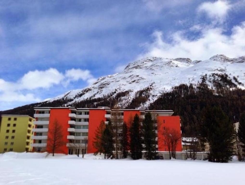 a building in the snow with a mountain in the background at Skyline 214 in St. Moritz