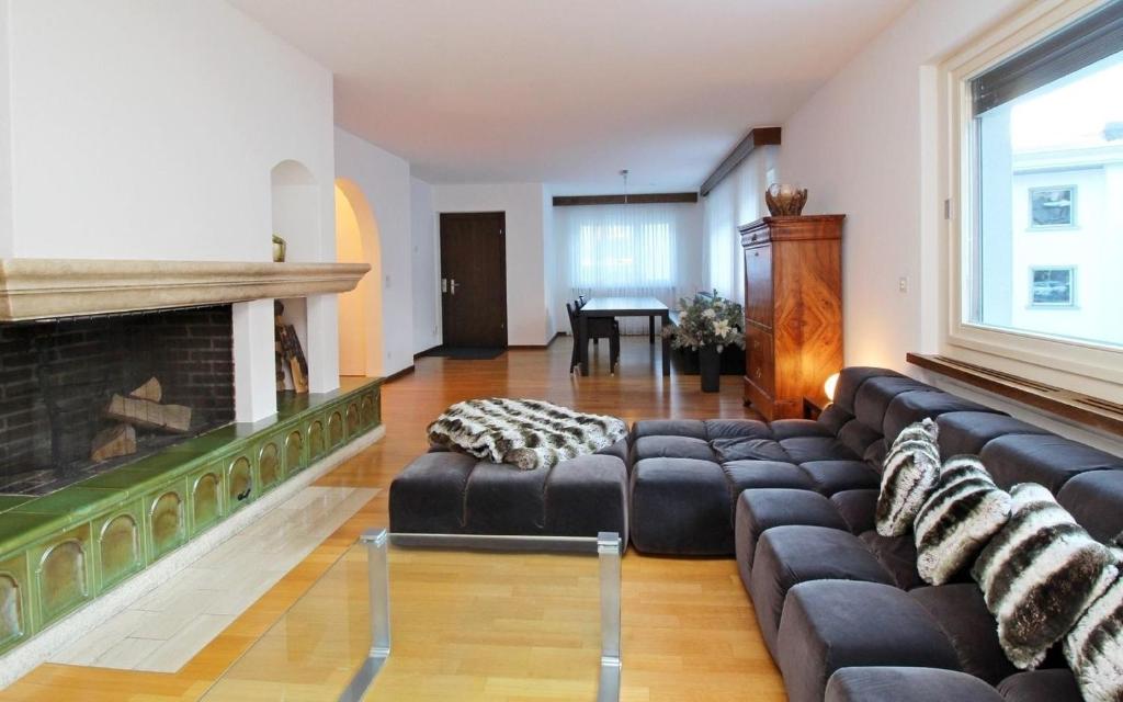 ein Wohnzimmer mit einem Sofa und einem Kamin in der Unterkunft Chesa Alice in St. Moritz
