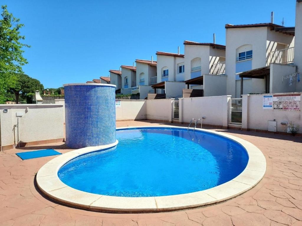 une grande piscine bleue dans une cour dans l'établissement Haus DORNA, à L'Escala