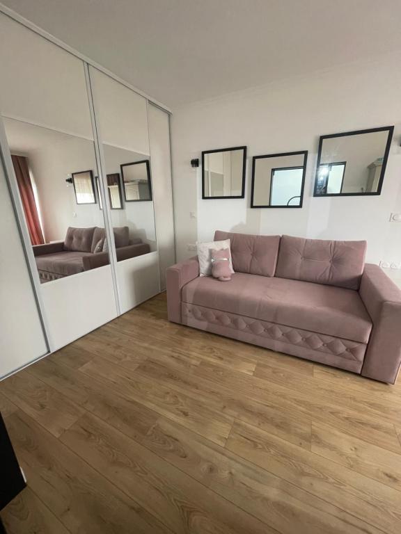 a living room with a couch and a mirror at Appartement 3 pieces 2 minutes à pied RER vers Paris in Gagny