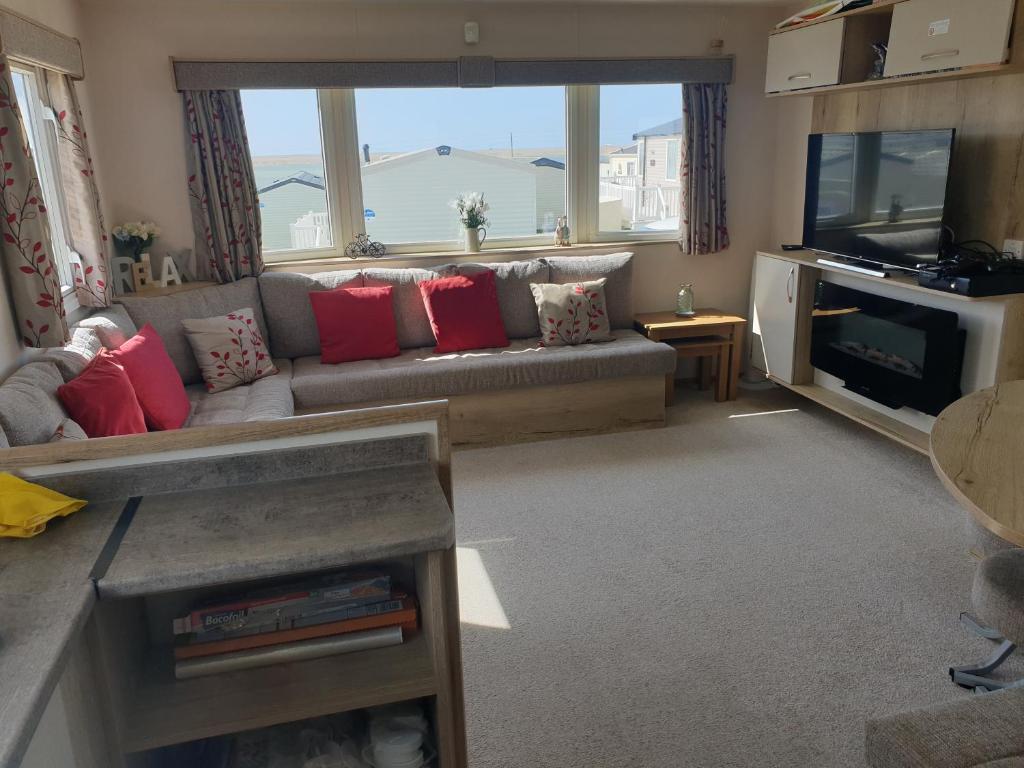 ein Wohnzimmer mit einem Sofa und einem TV in der Unterkunft Our Happy Place! in Weymouth