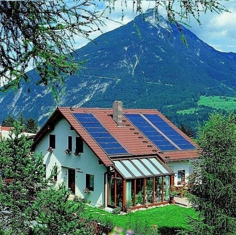 una casa con pannelli solari sopra di essa di Große Ferienwohnung in Imst mit Balkon und Panoramablick auf die Ötztaler und Pitztaler Alpen a Imst