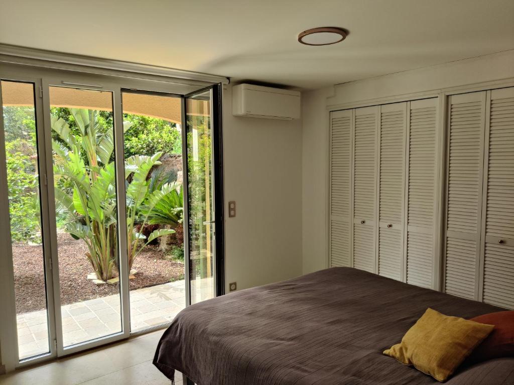 una camera da letto con un letto e porte scorrevoli in vetro di Villa de charme à 1 minute de la plage à pied a Banyuls-sur-Mer