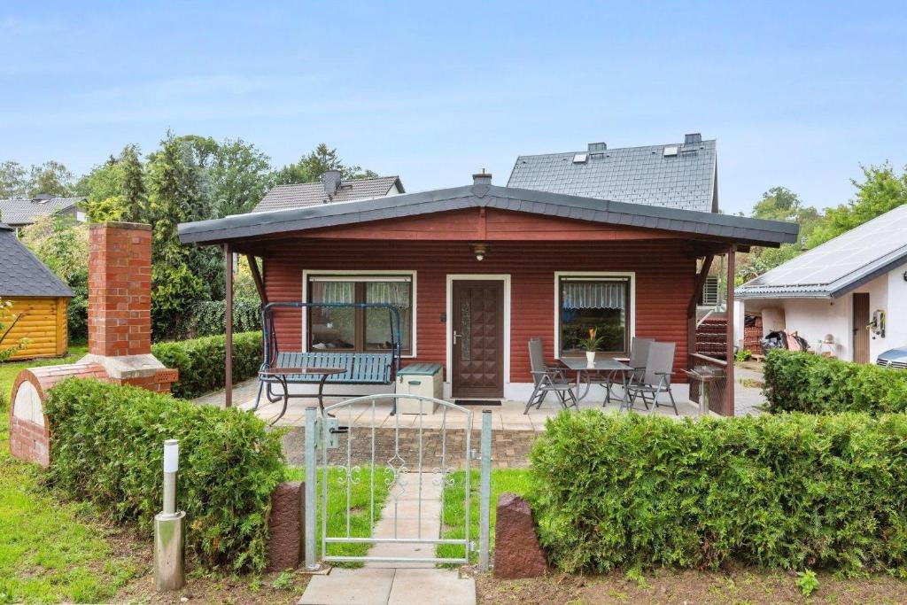a small house with a porch and a patio at Ferienhaus mit naturnahen Badeteich in Nordhausen