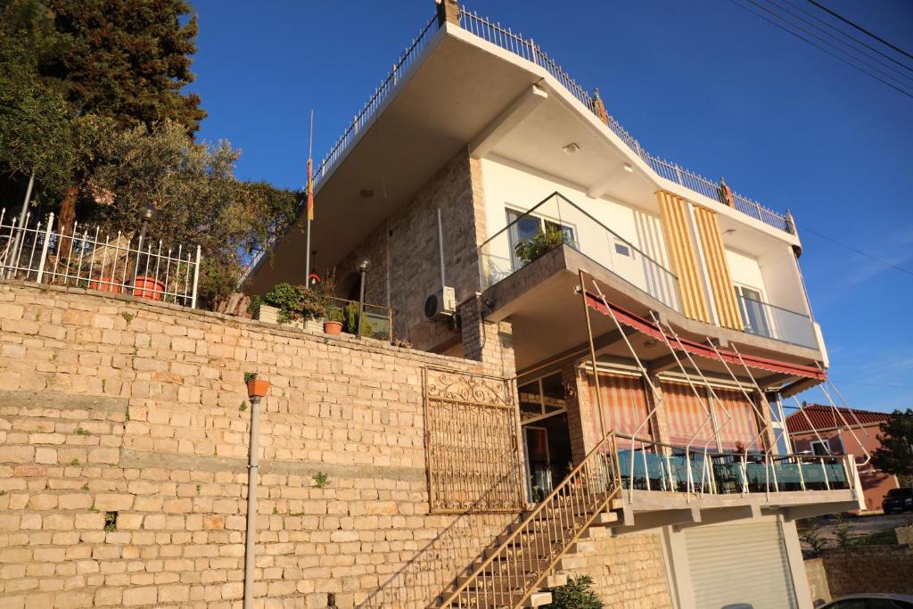 une maison construite au-dessus d'un mur de briques dans l'établissement Pamja e Qyteteve, à Krujë