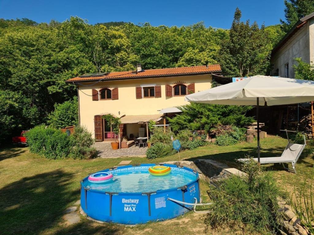 una casa con piscina en un patio con sombrilla en Wohnung in Mulazzo mit Großem Grill, en Mulazzo