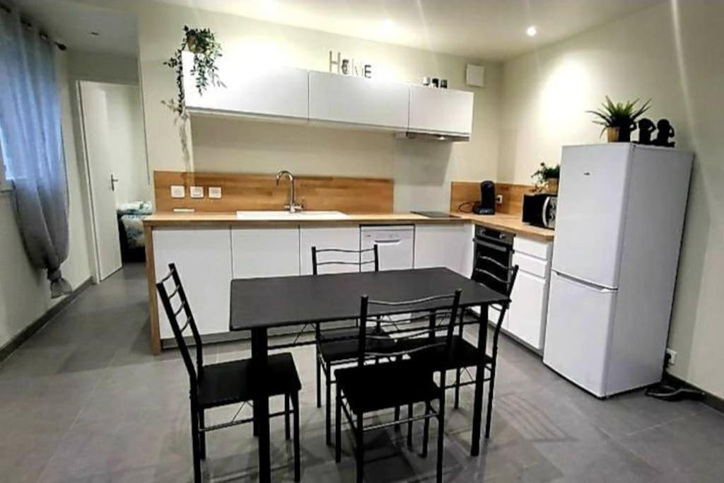 une cuisine avec une table, des chaises et un réfrigérateur dans l'établissement A proximité de toutes commodités, à Marseille