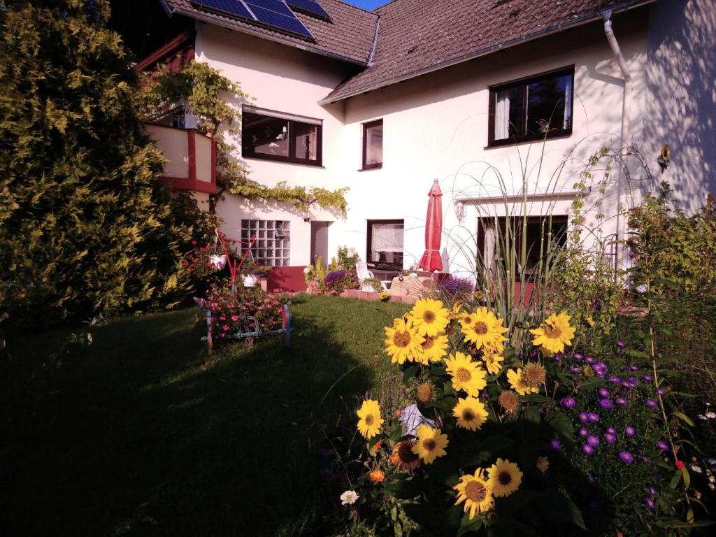 a house with flowers in the yard at Ferienwohnung Sonnenblume mit Finnischer Sauna in Daun
