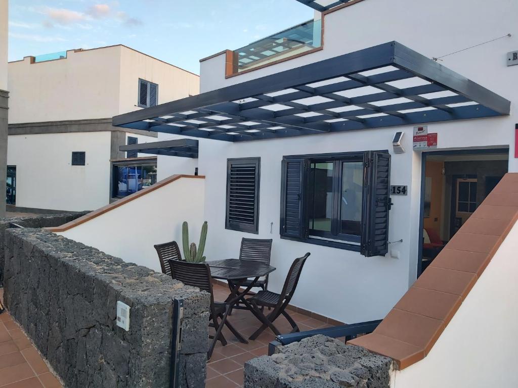 a house with a balcony with a table and chairs at Frataga Home in Playa Honda
