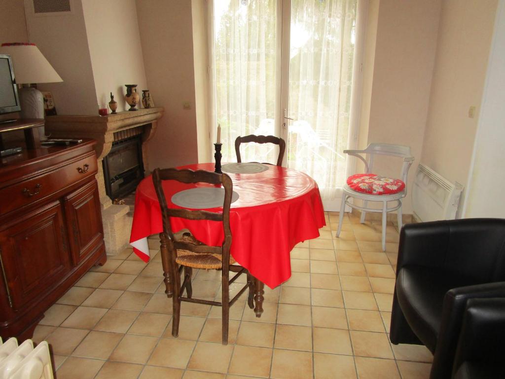 a dining room table with a red table cloth on it at la maisonnette du peu-morier in Vouvray