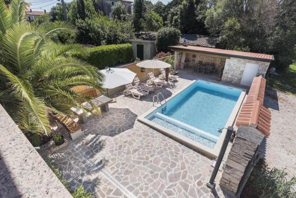 Pogled na bazen v nastanitvi Ruhig gelegenes Ferienhaus mit beheiztem Pool und Meerblick am Rande einer Olivenplantage oz. v okolici